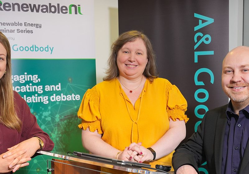 Niamh Collins, Zoe Crowe and Steven Agnew stand around a podium with RenewableNI banner behind them